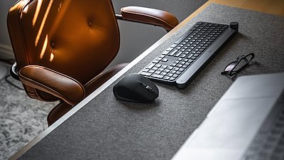 Schreibtisch mit Stuhl und Tastatur.