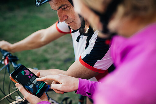 Sport bei Krebs: Zwei Menschen mit Smartphone im Vordergrund