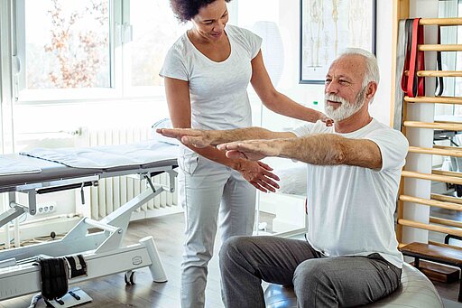 Physiotherapeutin und Krebspatient im Reha Sport. 