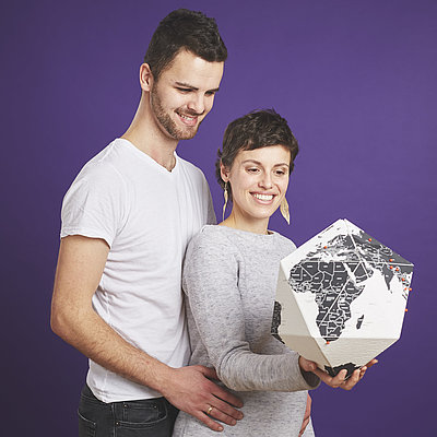 Brustkrebspatientin Tatiana und ihr Mann Farid betrachten gemeinsam ein Modell der Weltkarte