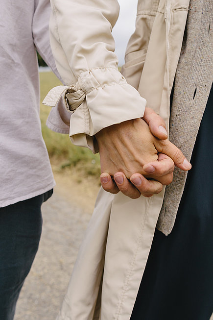 Zwei Personen spazieren Hand in Hand