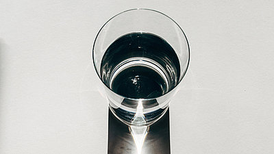 Ein Wasserglas, das einen langen Schatten wirft