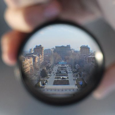 Ein Stadtpanorama hinter einer Kameralinse
