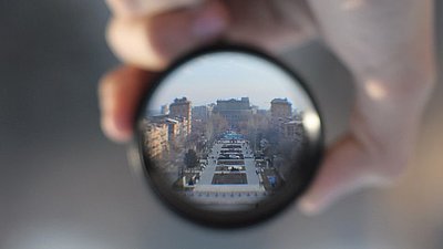 Ein Stadtpanorama hinter einer Kameralinse