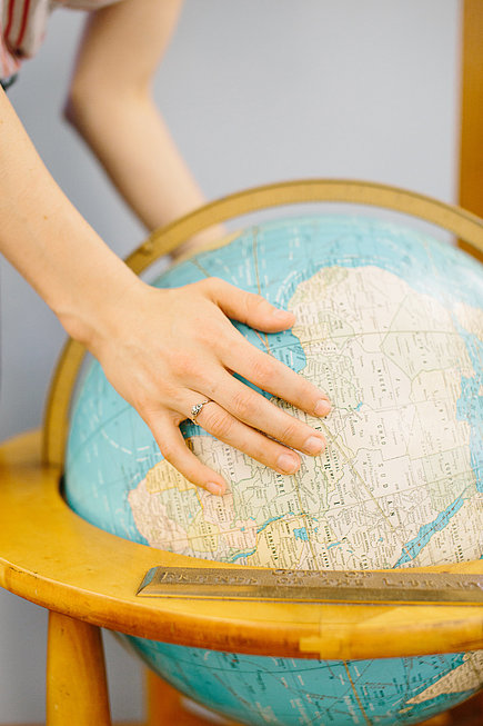 Weibliche Hände auf einem Globus