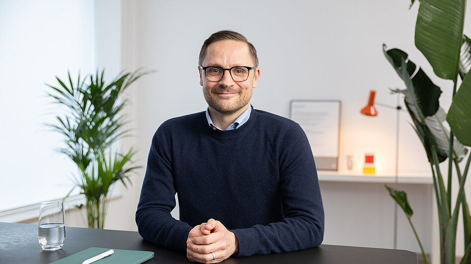 Bild von Onkologe Dr. Benedikt Westphalen, der an einem Schreibtisch sitzt