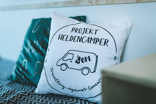 Ein Kissen mit Aufschrift „Projekt Heldencamper“
