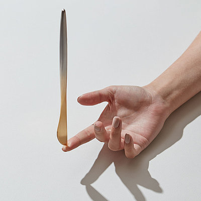 Ein Holzlöffel wird auf einer Fingerspitze balanciert.