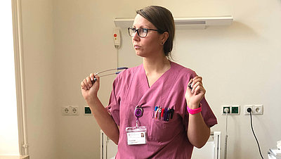 Onkologische Fachpflegerin Pauline Kludt mit einem Stethoskop in einem Krankenhauszimmer