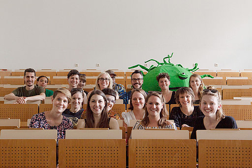 Gruppenfoto von jungen Männern und Frauen, die in einem Hörsaal sitzen.