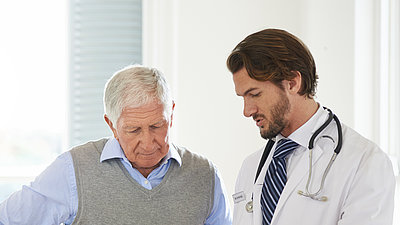 Älterer Mann im Gespräch mit einem Arzt