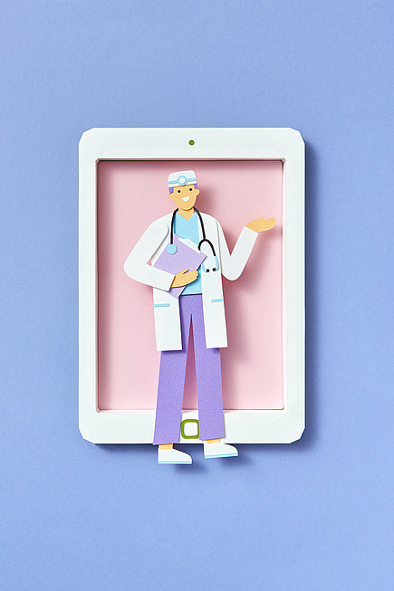 Doktor als Papierfigur vor einem Tablet